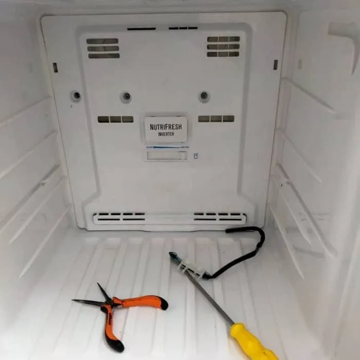 Technician servicing inverter fridge interior components